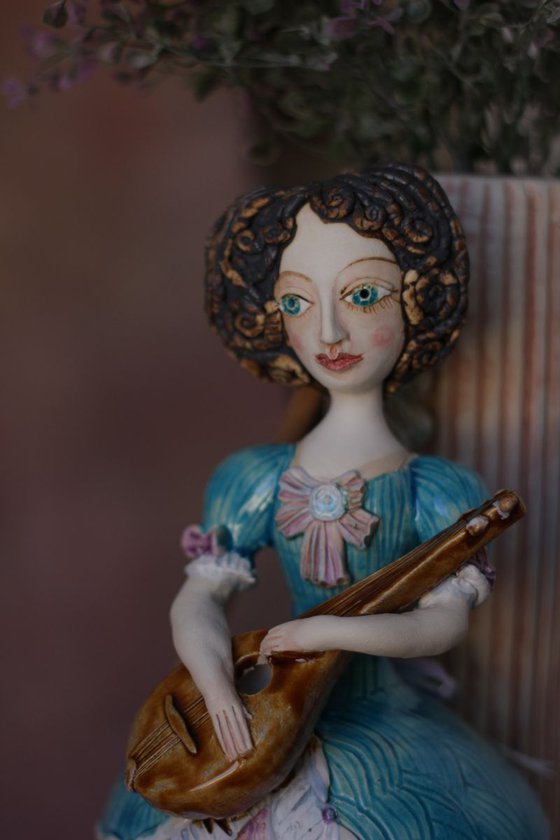 Blue dressed girl with mandolin. Wall ceramic sculpture by Elya Yalonetski.