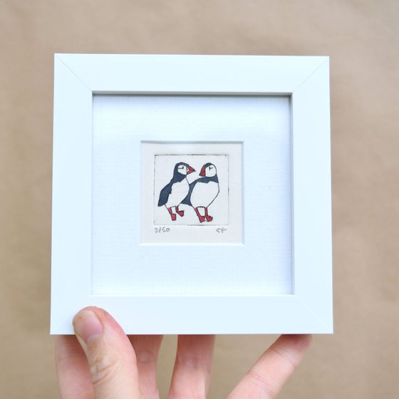 Mini framed two puffins standing close and looking at each other