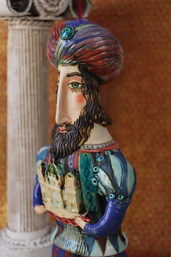 Oriental king holding a cathedral in his hands. Hanging sculpture, Bell-doll