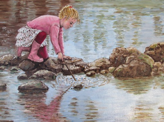 Girl in pink boots playing by a lake