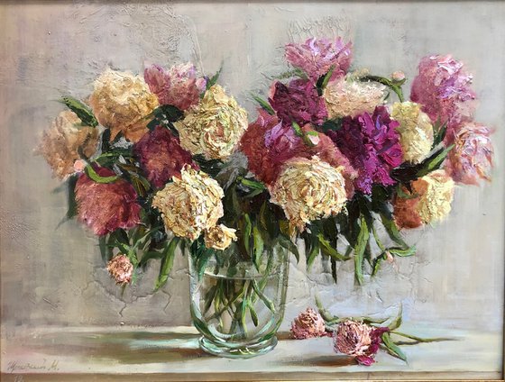 "A bouquet of peonies in a glass vase"