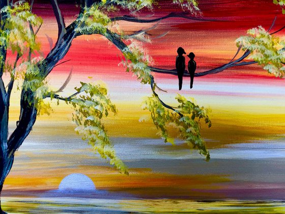 Love birds in a tree by sunset