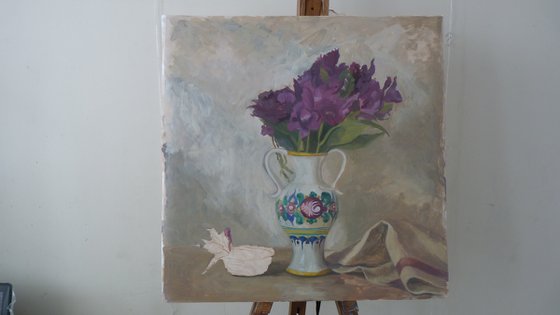 Purple flowers in a colorful jug