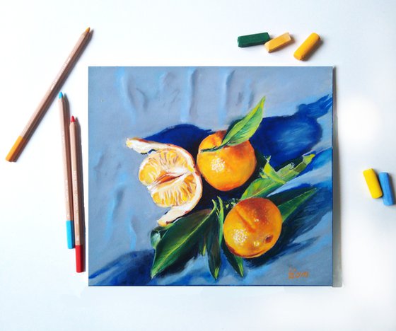 Three tangerines on blue