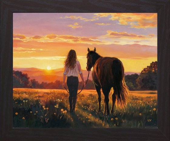 Woman walking with a horse in a sunset field