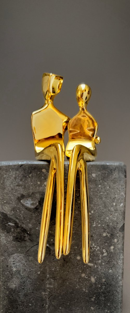 "Caress" a small  gold-plated bronze sculpture of a loving couple by Yenny Cocq