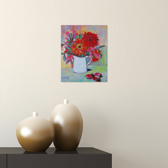 Flowers in a jug with strawberries.