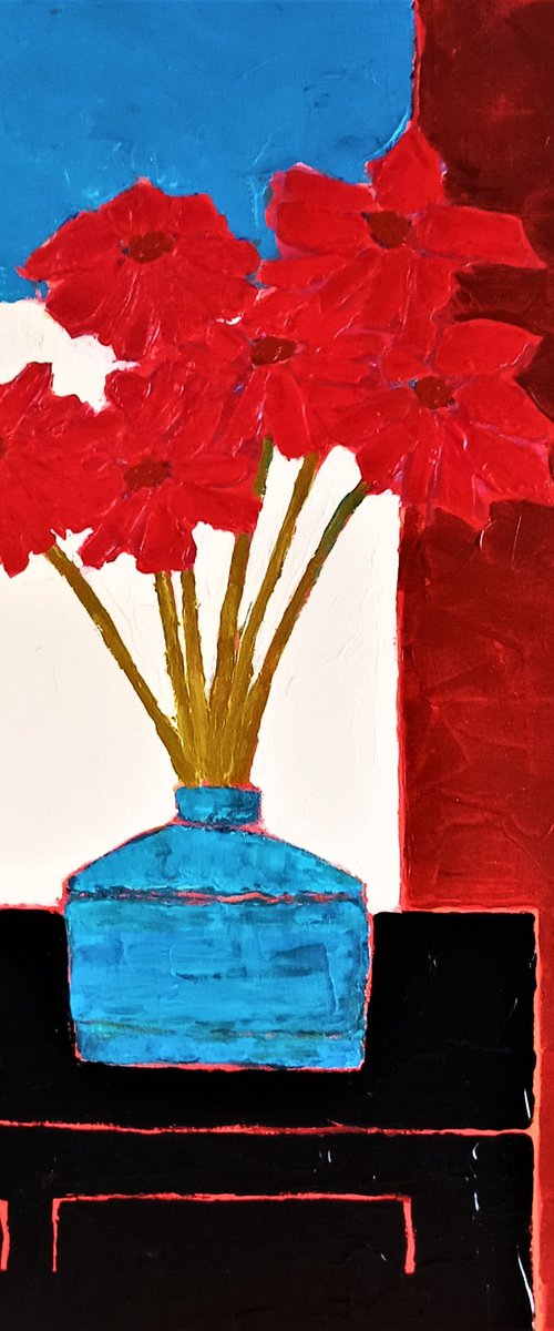 RED FLOWERS IN AN OLD BLUE VASE ON A BLACK CREDENZA by David J Edwards