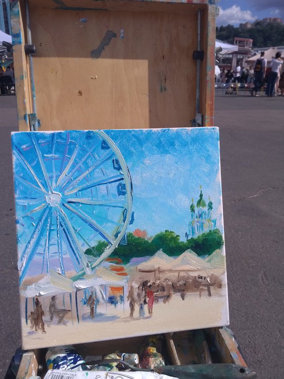 City square with a Ferris wheel and the city festival. Pleinair painting