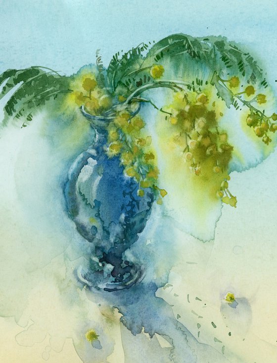 A sprig of mimosa in a small blue vase. Still life. Spring.