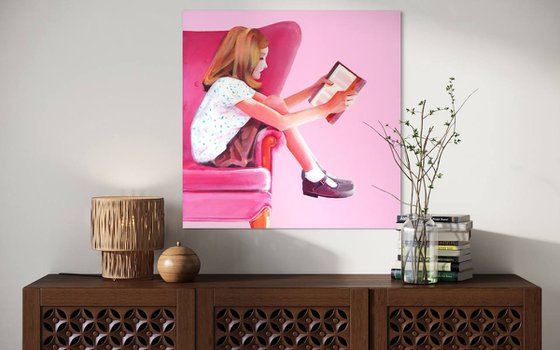 Girl in pink chair with book