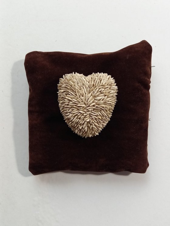 Small heart on a brown pillow