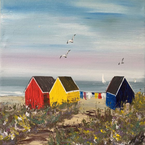 Three beach huts on the beach on a square canvas