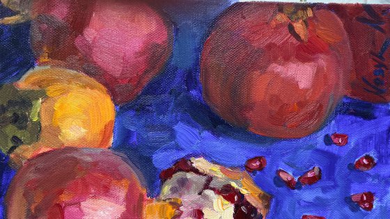 Pomegranates and persimmons on blue