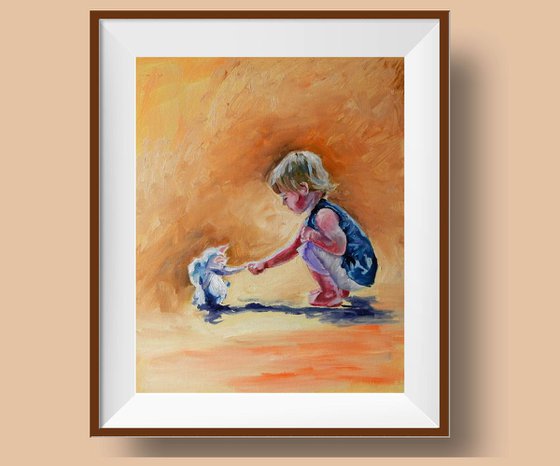 A Boy playing with a cat/kitten.