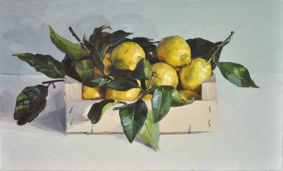Lemons with leaves in a crate