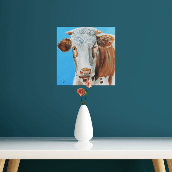 Cow painting a portrait in blue