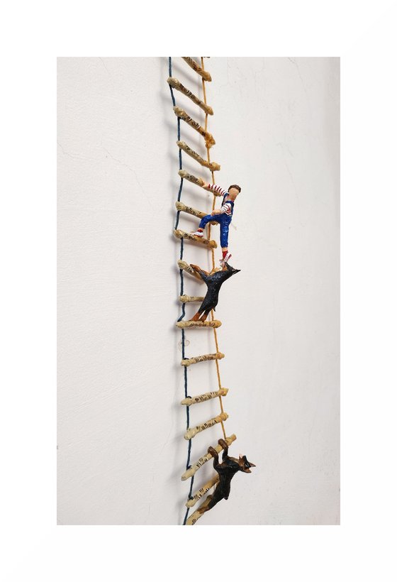 Two Dobermans and the figure on the ladder