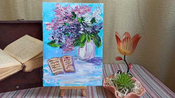 Lilac flowers and a book still life