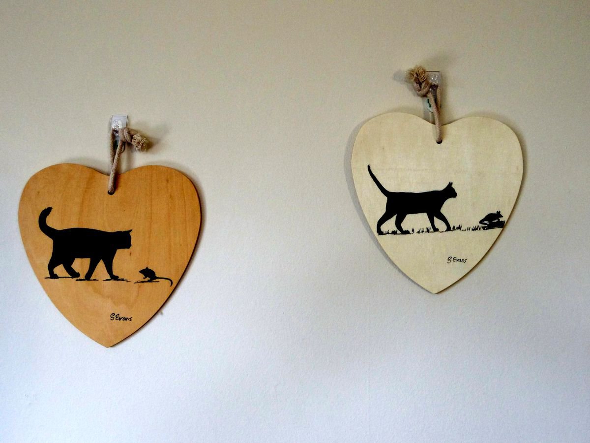 A pair of wooden heart paintings. I AM BEHIND YOU / CAT AND MOUSE by Graham Evans