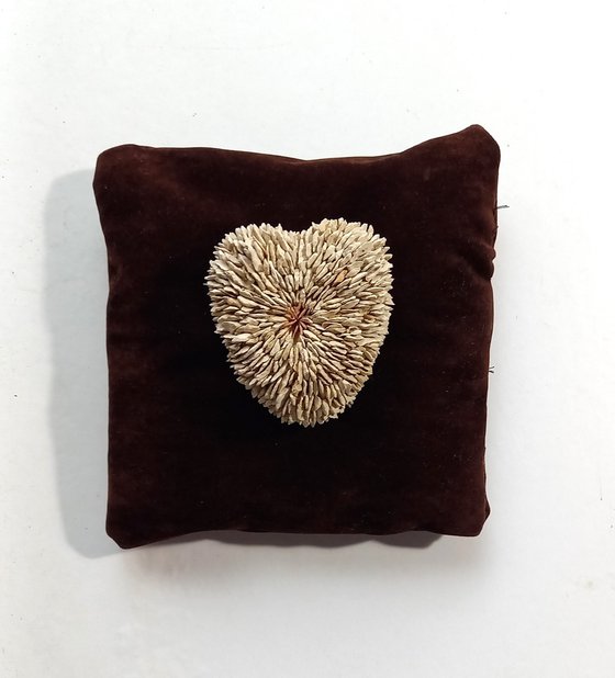 Small heart on a brown pillow
