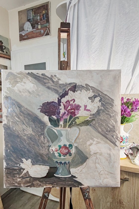 Purple flowers in a colorful jug