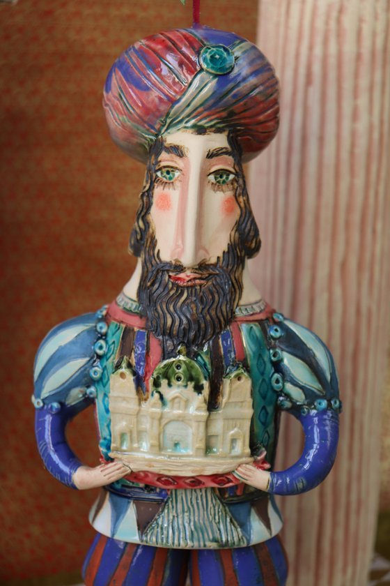 Oriental king holding a cathedral in his hands. Hanging sculpture, Bell-doll