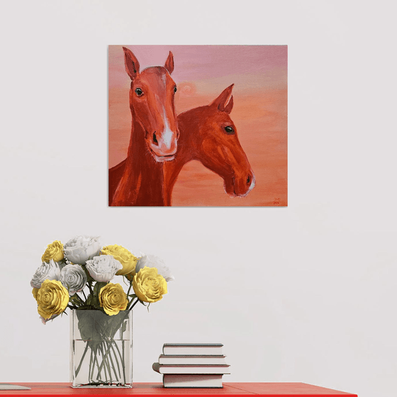Chestnut horses at soft pink orange sunset