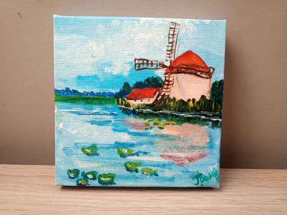 Windmill on the river bank. Miniature painting