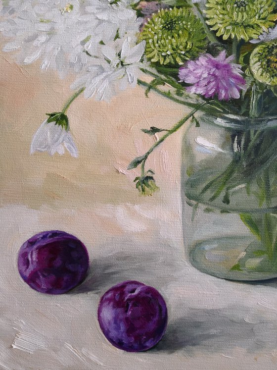 Asters  flower bouquet in a glass jar with pulms aside still life