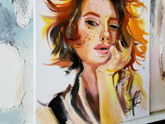 Portrait of a red-haired girl on canvas with oil paints