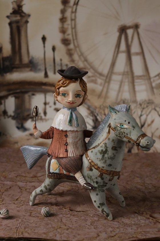 Vintage dressed boy riding a blue horse. From "Le Carousel, Hommage à l'Innocence" project by Elya Yalonetski