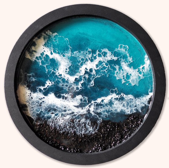 Round window overlooking the sea in a black frame