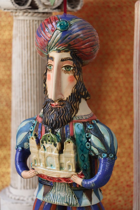 Oriental king holding a cathedral in his hands. Hanging sculpture, Bell-doll