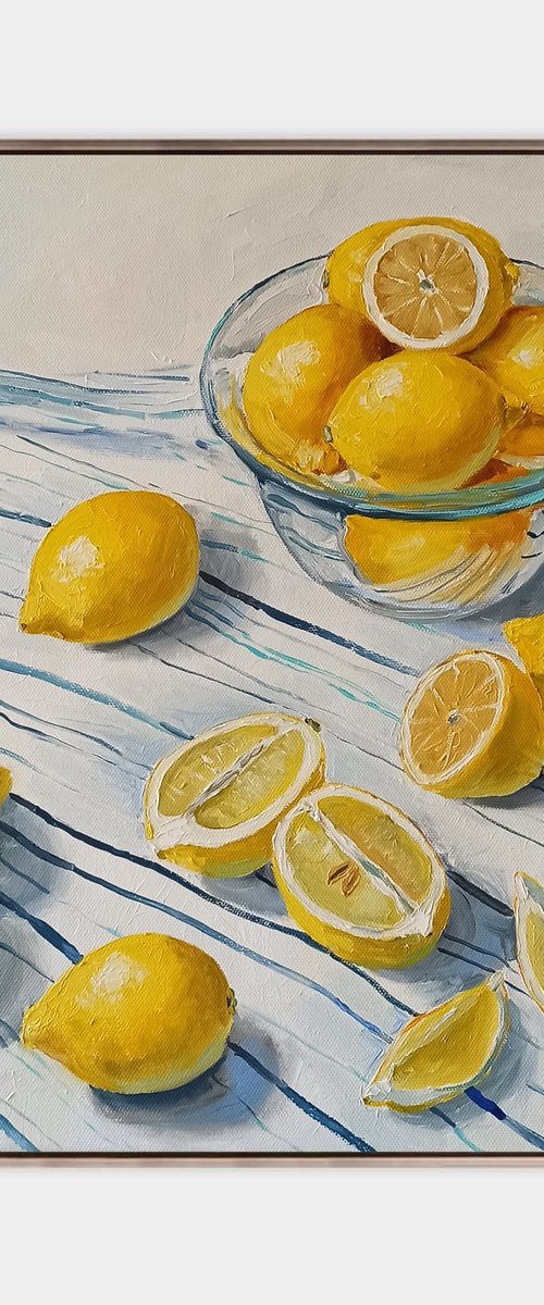 Lemons in glass bowl on stripen tablecloth by Leyla Demir