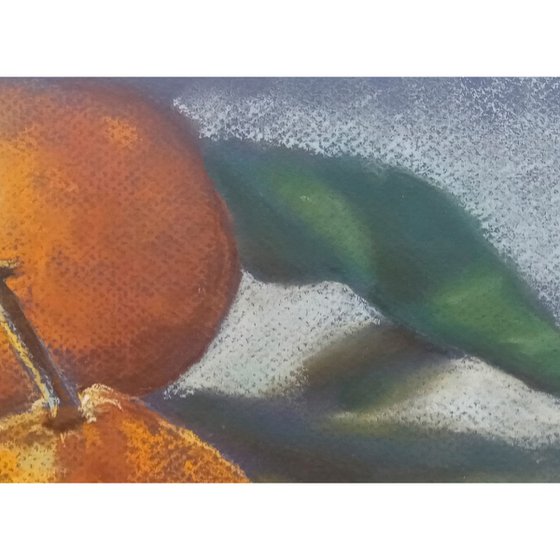 Ripe tangerine with a green leaf