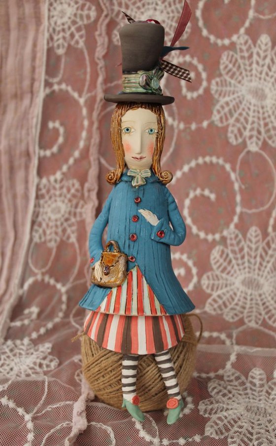 Vintage dressed girl with a handbag. Small ceramic sculpture, bell-doll