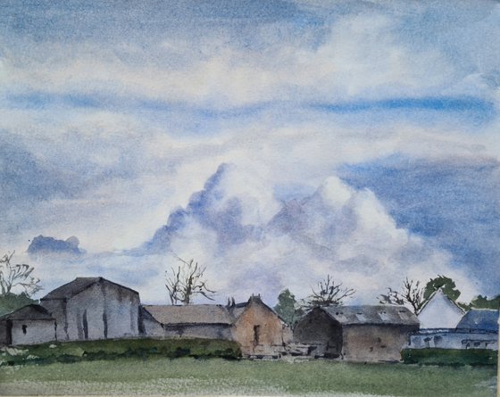 Cloud formations over farm buildings