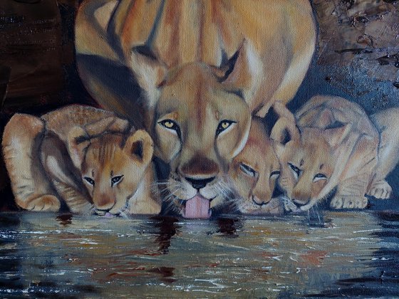 Lioness with cubs by the water