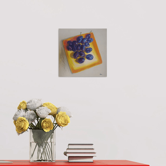 Blue plums on a yellow dish
