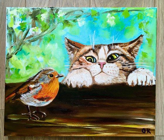 Curiosity, feline look. Cat and robin.  Spring time.