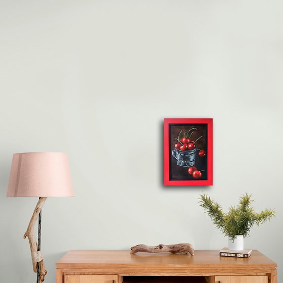 Red cherries in a metal cup