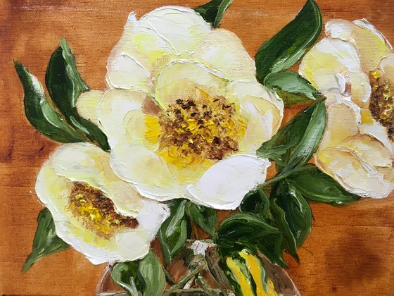 Bouquet of wild yellow roses in a vase on wooden table.