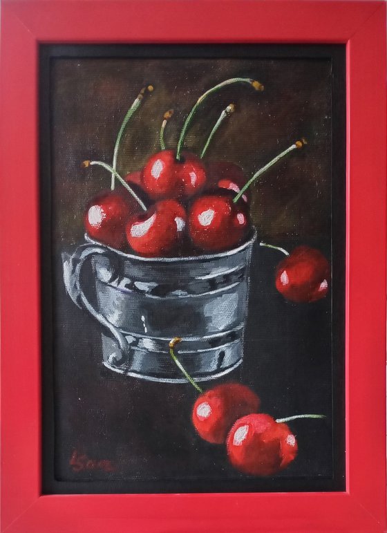 Red cherries in a metal cup