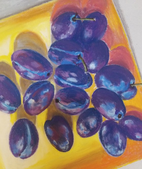 Blue plums on a yellow dish