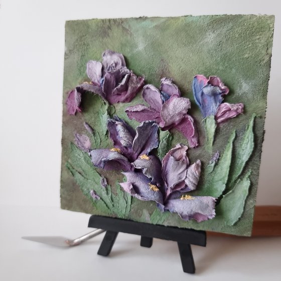 Miniature purple irises. A small floral botanical relief. 3d painting of spring flowers with ceramic petals.