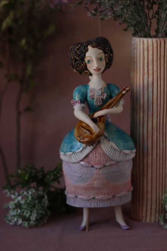 Blue dressed girl with mandolin. Wall ceramic sculpture by Elya Yalonetski.