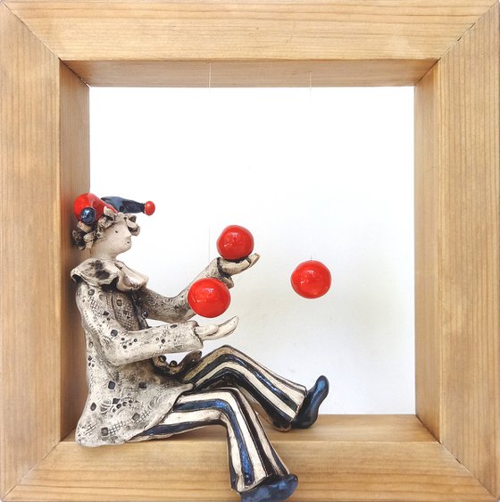 A clown playing with balls