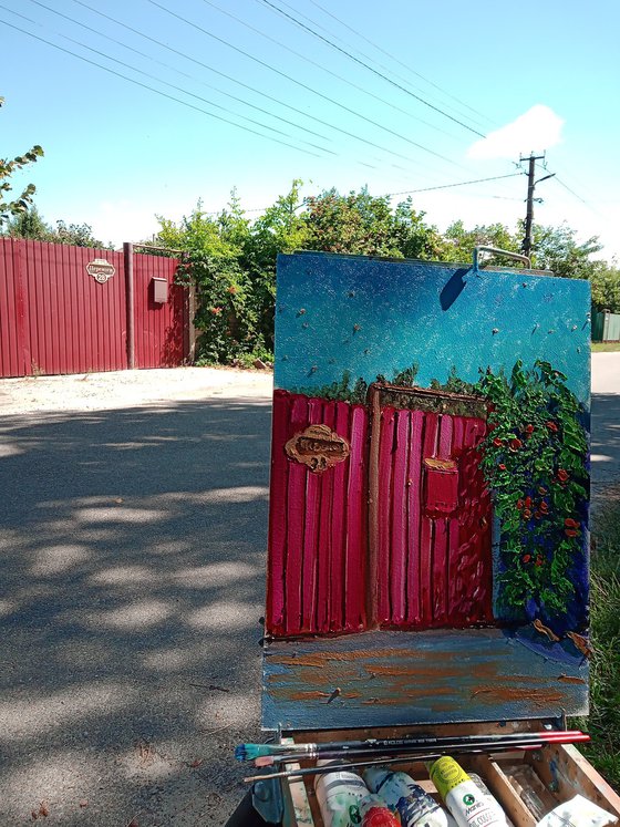 Red fence covered by flowers at the village street