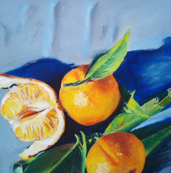 Three tangerines on blue